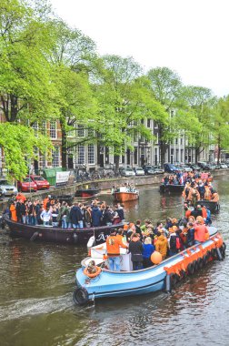 Amsterdam, Hollanda - 27 Nisan 2019: Hollanda Kralı Willem-Alexander 'ın doğum günü olan Koningsdag, Krallar Günü' nü kutlarken ulusal turuncu renkte giyinmiş insanlarla dolu parti tekneleri.