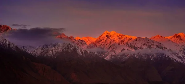 Hermoso amanecer nublado en las montañas con cresta de nieve —  Fotos de Stock