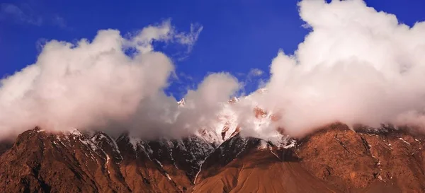 Beautifull cloudy sunrise in the mountains with snow ridge — Stock Photo, Image