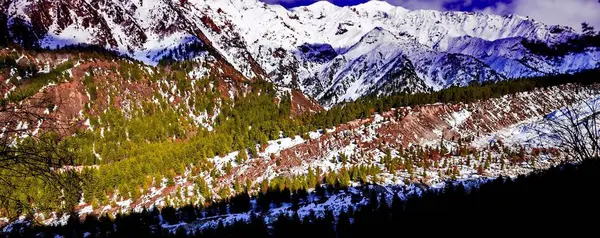 Belíssimo nascer do sol nublado nas montanhas com cume de neve — Fotografia de Stock