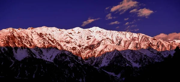 Beau lever de soleil nuageux dans les montagnes avec crête de neige — Photo
