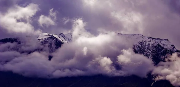 Beautifull cloudy sunrise in the mountains with snow ridge — Stock Photo, Image