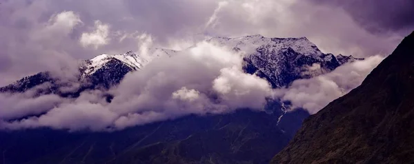 Beautifull cloudy sunrise in the mountains with snow ridge — Stock Photo, Image