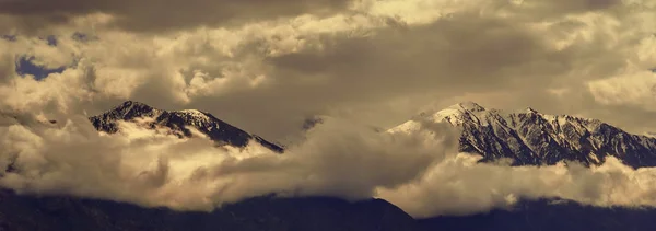 Beautifull cloudy sunrise in the mountains with snow ridge — Stock Photo, Image