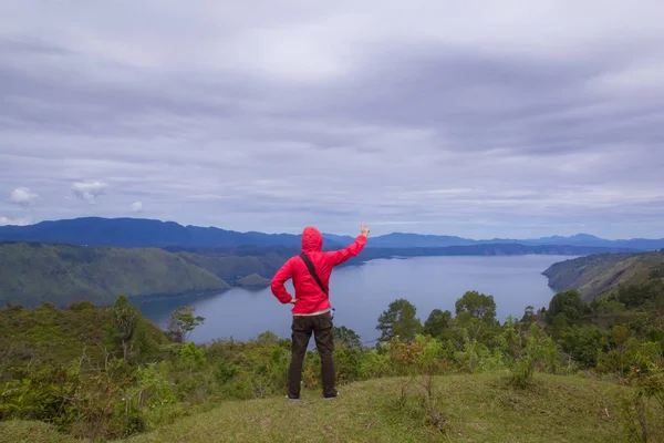 Hombre de pie en la colina mirando el lago toba — Foto de Stock