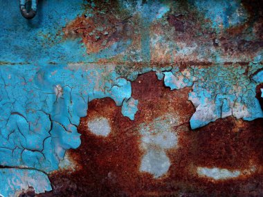 Mavi bir yüzeyde pas. Boyada çatlaklar var. Eski demir. Metaldeki paslı lekeler. Arkaplan