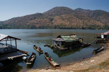Tahta ev ya da dinlenme tesisi doğanın güzelliğiyle nehirde yüzüyor. Mountain, temiz hava ve Srinagarind Barajı Gölü 'nde yeşil bitki, Kanchanaburi, Tayland. Seyahat için simge