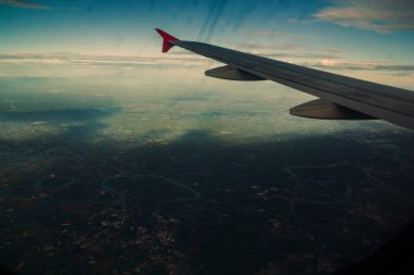 Chao Phraya nehrinin yanındaki kırsal alanda, çevredeki yerleşim alanlarının ve yeşil pirinç tarlalarının havadan görüntüsü.