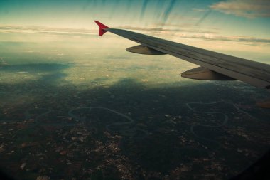 Chao Phraya nehrinin yanındaki kırsal alanda, çevredeki yerleşim alanlarının ve yeşil pirinç tarlalarının havadan görüntüsü.