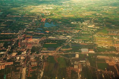 Chao Phraya nehrinin yanındaki kırsal alanda, çevredeki yerleşim alanlarının ve yeşil pirinç tarlalarının havadan görüntüsü.