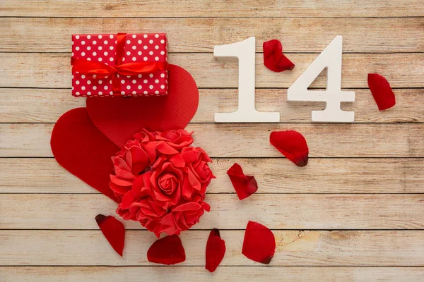 Wooden background with hearts, flowers, gifts, petals and wooden numbers of dated 14 February. The concept of Valentine Day.