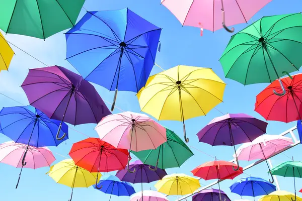 Mavi arkaplanda çok renkli şemsiyeler