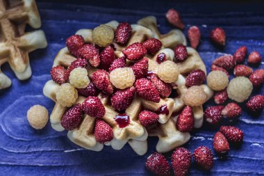 Mavi ahşap arka planda meyveli ev yapımı waffle. Lezzetli, besleyici, fantastik kahvaltı ya da tatlı