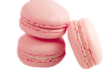 Lezzetli Fransız tatlısı. Üç yumuşak pastel yumuşak pembe kek ya da beyaz arka planda izole edilmiş badem kurabiyesi..