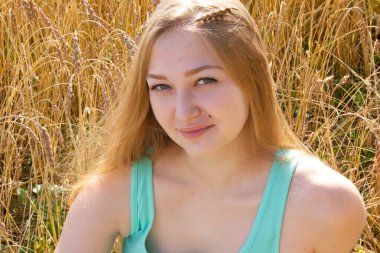 Mutlu genç kız altın olgun buğday tarlasında yürüyor