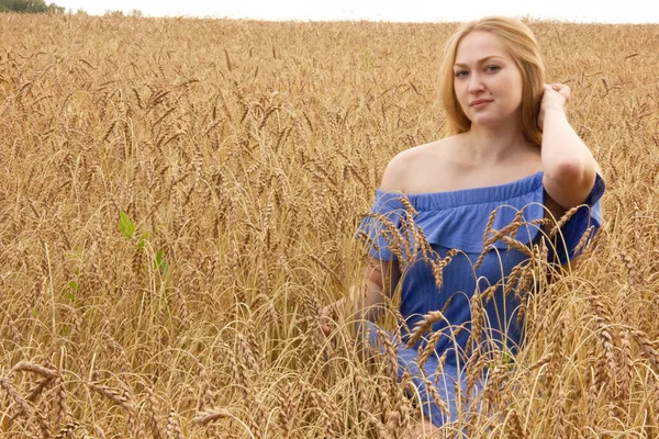 Heureuse jeune fille marche dans un champ de blé mûr doré — Photo
