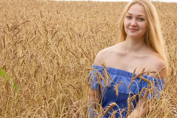 Heureuse jeune fille marche dans un champ de blé mûr doré — Photo