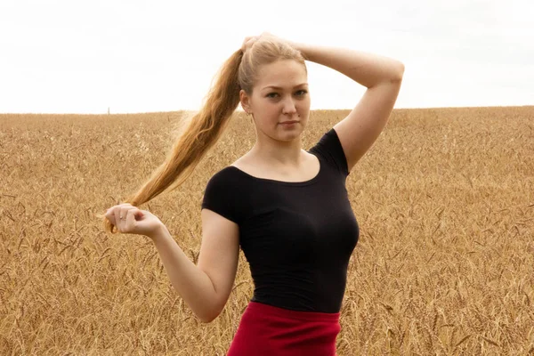 Heureuse jeune fille marche dans un champ de blé mûr doré — Photo