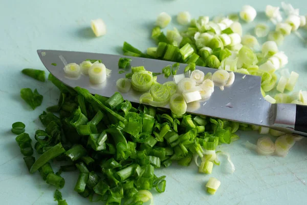 Cebollas verdes frescas finamente picadas. Las etapas intermedias de la cocción Fotos De Stock