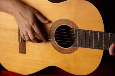 Kadın elleri akustik gitar tutuyor. müzik çal.