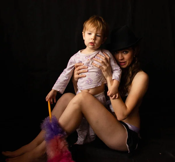 Sexig tjej i erotisk kostym med pi pi dastre, flerfärgad ljus borste för damning. Bredvid sin son — Stockfoto