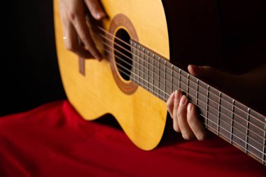Kadın elleri akustik gitar tutuyor. müzik çal.