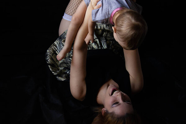 Мама обнимается со своим ребенком и целуется на черном фоне. Счастливого детства
.