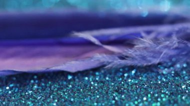 blue feather on a blue shiny background swaying from the wind and flies away