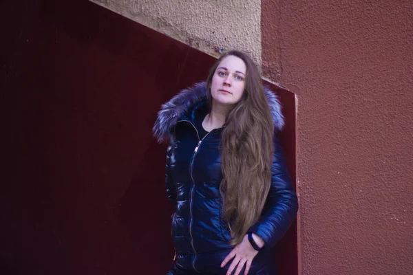 Una joven con una chaqueta con el pelo largo y suelto en las escaleras posa . —  Fotos de Stock