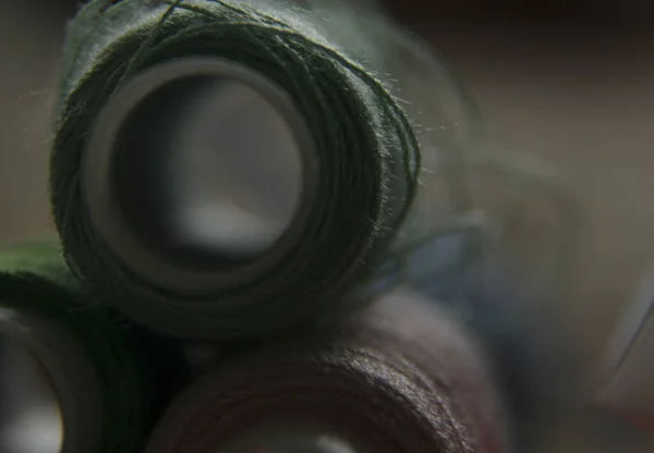 macro-shooting coils with multi-colored threads. close-up of sewing threads