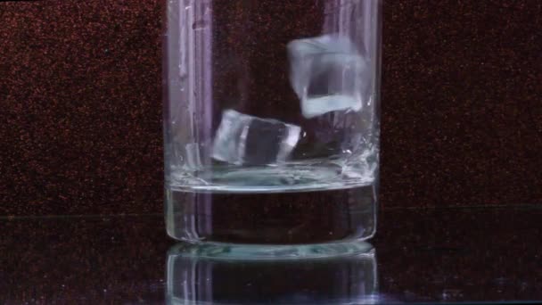 在透明的玻璃杯中 冰块落在黑色的背景上 — 图库视频影像