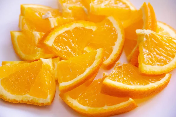 Cuñas anaranjadas cortadas en un plato blanco. excelente merienda y la riqueza de vitaminas —  Fotos de Stock