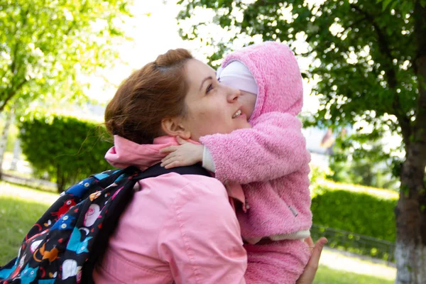 Mama Siedzi Trawie Cieniu Kwitnącej Jabłoni Gra Przytula Swoje Córki — Zdjęcie stockowe