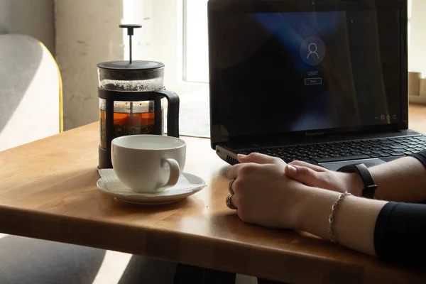 Vacker sexig tjej i svart klänning och glasögon sitter vid bordet och arbetar vid datorn. Distansundervisning. Fjärrarbete — Stockfoto