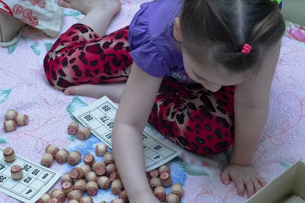 Çocuk loto oynuyor. Fıçıları ellerinizde tutun. Hafta sonu masa oyunu ve evde izolasyon