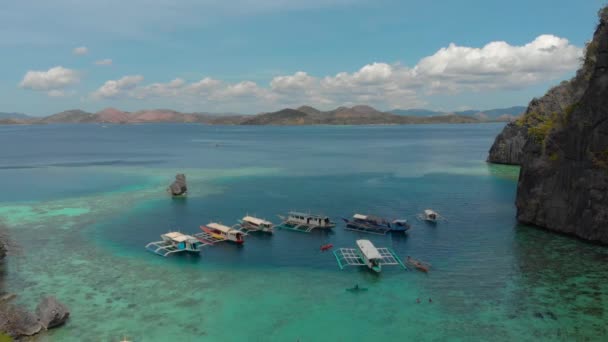 Τουριστικά σκάφη κοντά στα βράχια στα γαλαζοπράσινα νερά στο νησί Coron, Φιλιππίνες — Αρχείο Βίντεο