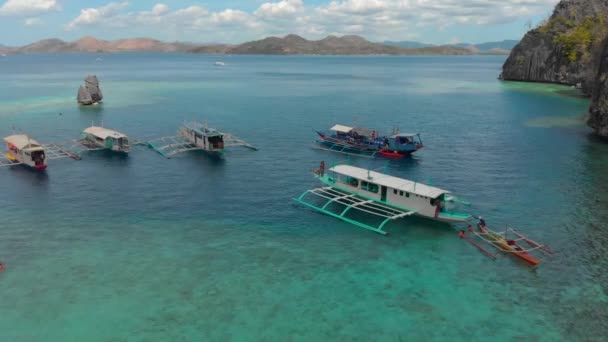 Barcos turísticos cerca de los acantilados en aguas turquesas en la isla de Coron, Filipinas — Vídeos de Stock