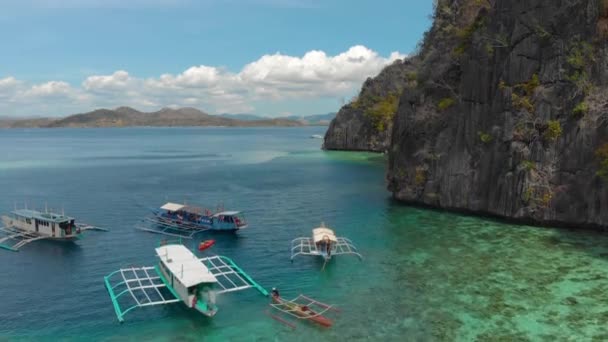 Barcos turísticos cerca de los acantilados en aguas turquesas en la isla de Coron, Filipinas — Vídeo de stock