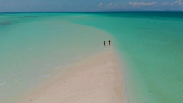 4K在菲律宾巴拉望的曼萨兰根沙洲 一对可爱的旅行情侣站在无尽的白沙滩上 四周环绕着碧绿的水 — 图库视频影像