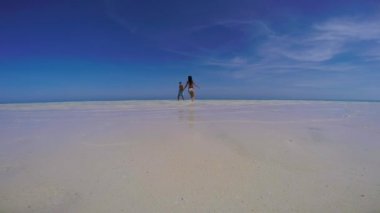 Balabac Palawan Filipinleri 'ndeki Mansalangan Kum Barında açık mavi gökyüzünde oynayan sevimli seyahat çifti. Beyaz kumsalda turkuaz su