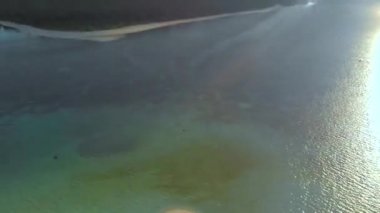 Filipinler 'in Balabac kentindeki Candaraman Adası' nda gün batımında palmiye ağaçlarının 4k hava manzarası. Tropikal adada gün batımı bir sürü palmiye ağacı ile çevrilidir..