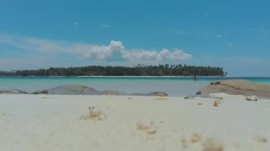 İzole edilmiş tropikal adada yalnız bir kadının hava görüntüsü. Filipinler 'in Balabac kentindeki Timbayan Adası' nda turkuaz suyla çevrili beyaz kumda tek başına bir kız.