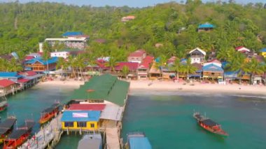 Beyaz plaj ve palmiye ağaçlarıyla çevrili geleneksel renkli evleri olan tropik bir sahil. Kamboçya 'daki Koh Rong adasının hava manzarası.