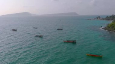 Koh Rong Adası 'ndaki Koh Touch köyünde hava batımı ve Kamboçya' daki rıhtımda ve denizde bir sürü tekne.