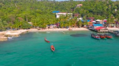 Koh Rong Adası 'ndaki Koh Touch köyünde hava batımı ve Kamboçya' daki rıhtımda ve denizde bir sürü tekne.