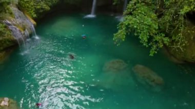 Cebu Adası, Filipinler 'deki Kawasan Şelalesi. İnsanlar şelalenin doğal havuzunda yüzüyor.
