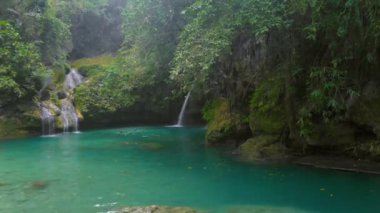 Filipinler 'deki Cebu Adası' ndaki Kawasan Şelalesi 'nde tropik yeşil ormanın ortasındaki hava şelalesi manzarası..