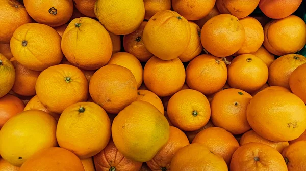 Healthy and organic oranges at the market. Lots of fresh orange fruits background.