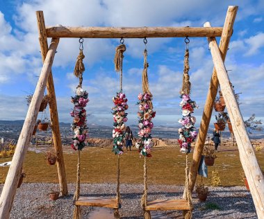 Kapadokya 'daki vadi manzaralı ahşap salıncakta renkli çiçekler