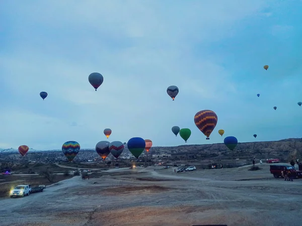 在土耳其 多彩的热气球在冬季清晨飞越卡帕多西亚上空 而在黑暗的早晨飞行 — 图库照片